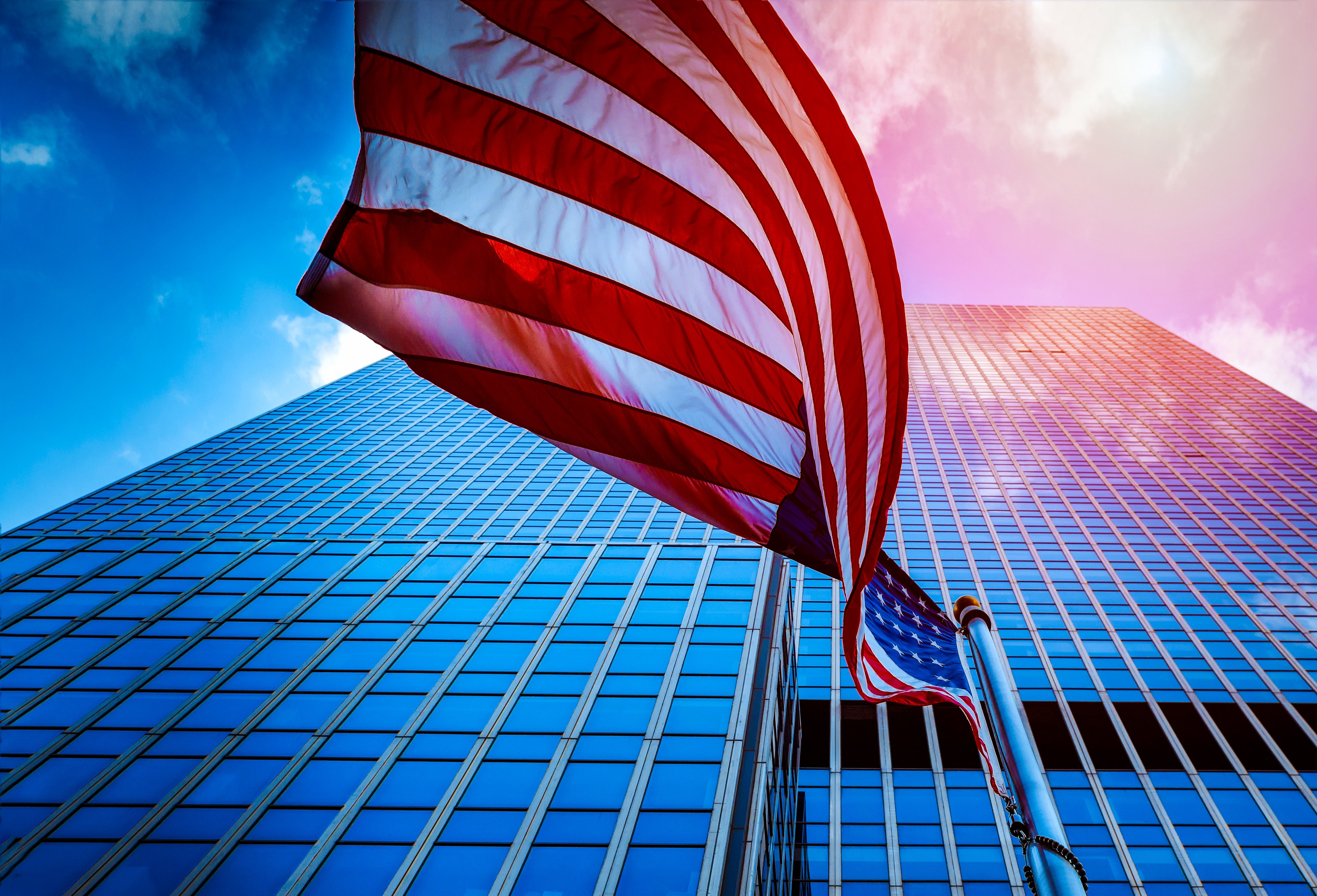 View of the flag waving of the United States of America in the a High Rise Glass Tower