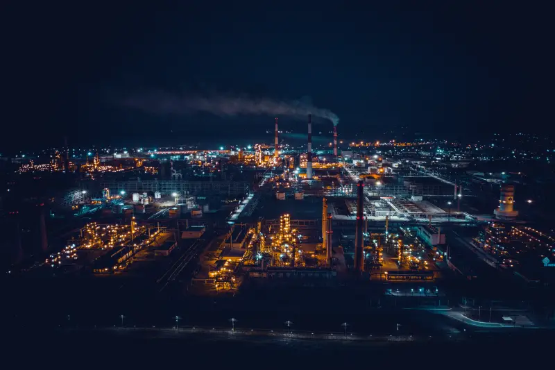 Oil and gas oil refinery at night. Pipes and large tanks with night lights