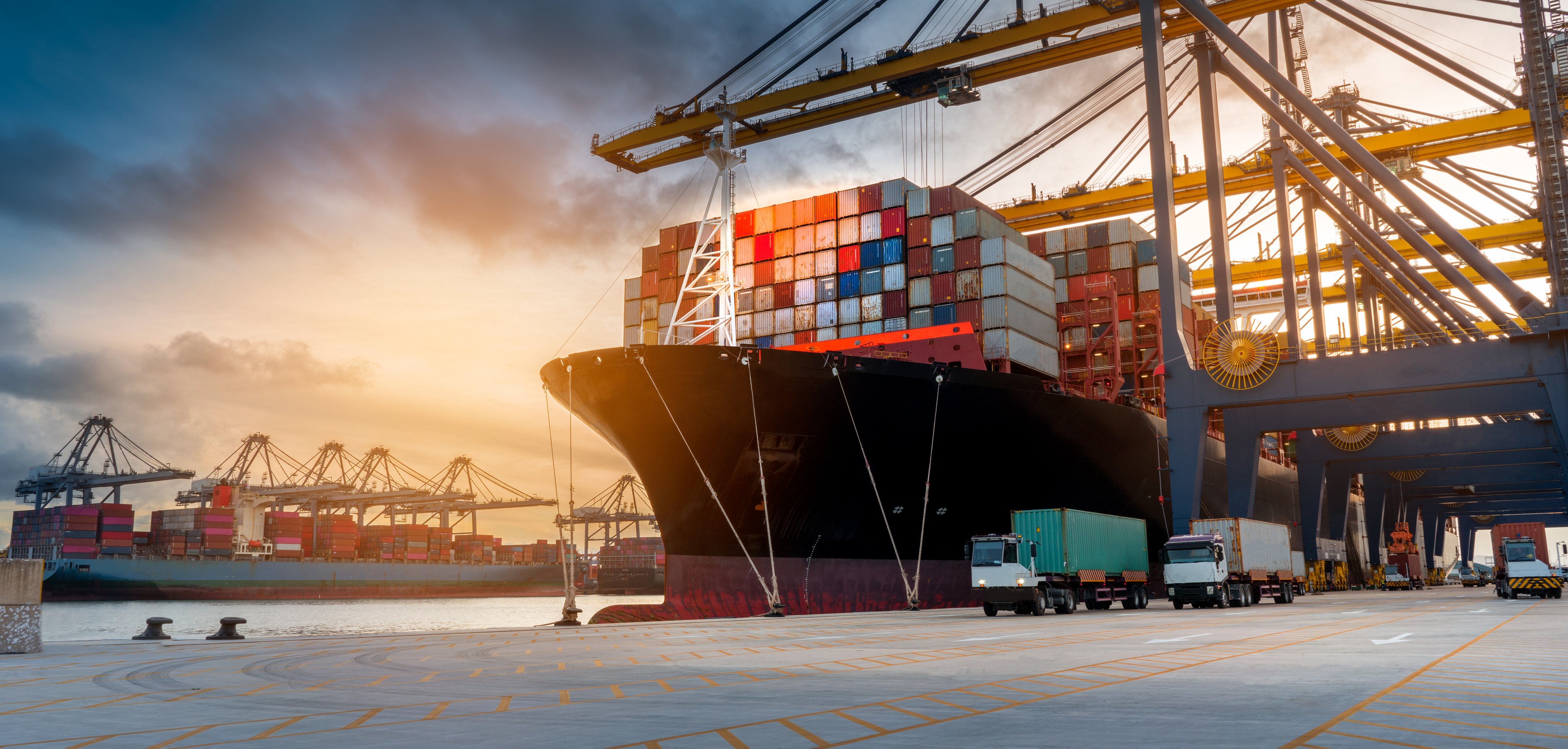 crane loading cargo container from truck to container ship in the international terminal logistic sea port concept freight shipping by ship 