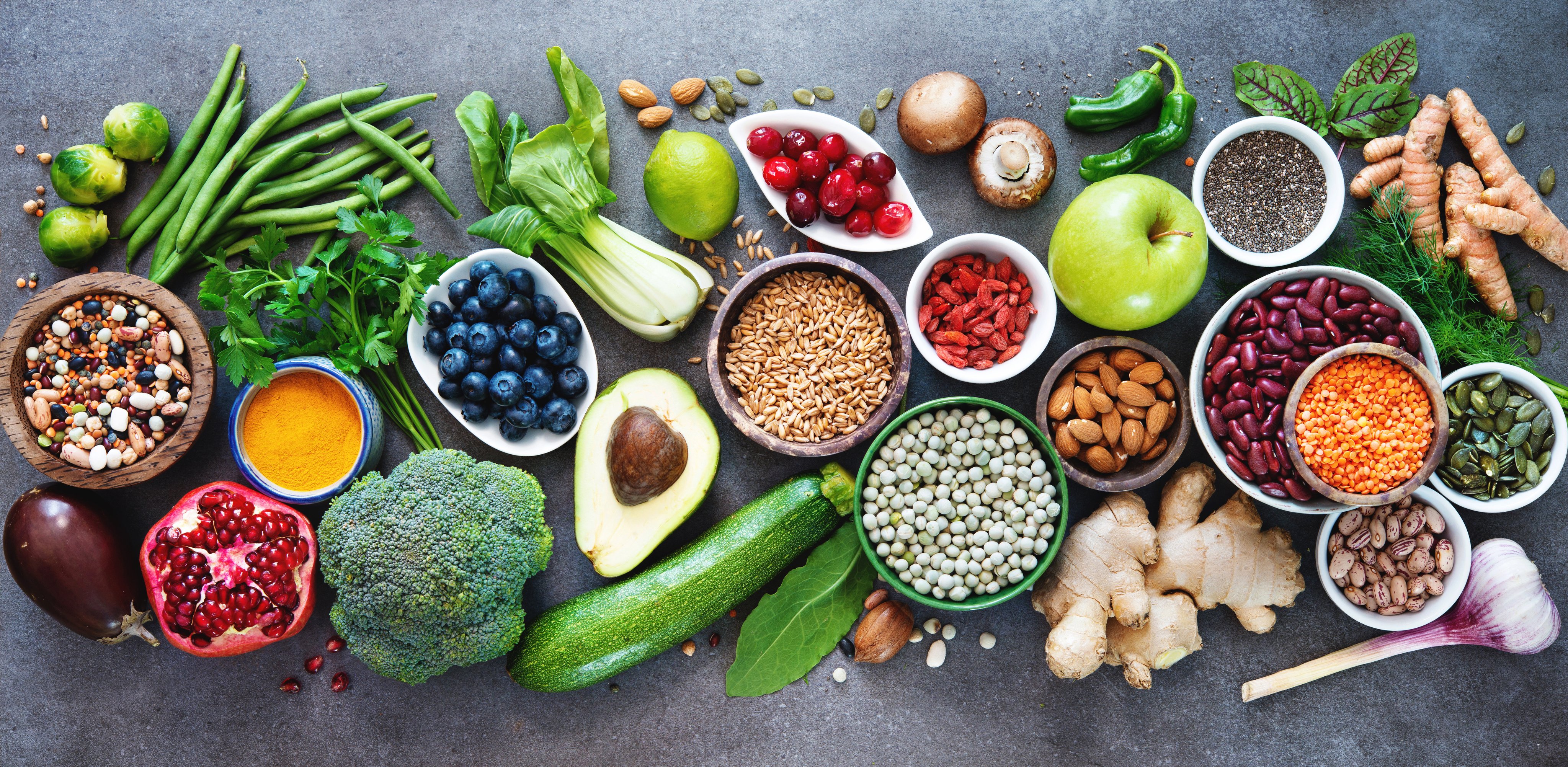 Healthy food selection with fruits, vegetables, seeds, superfood, cereals on gray background