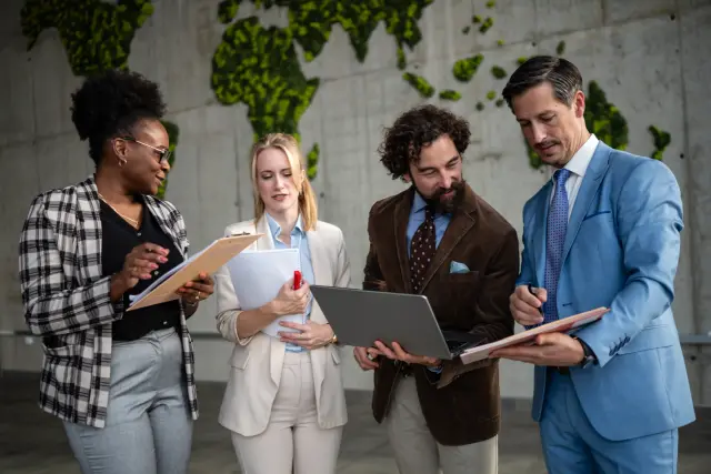 Business professionals discussing work in a modern office with a moss map wall, fostering global teamwork and innovation