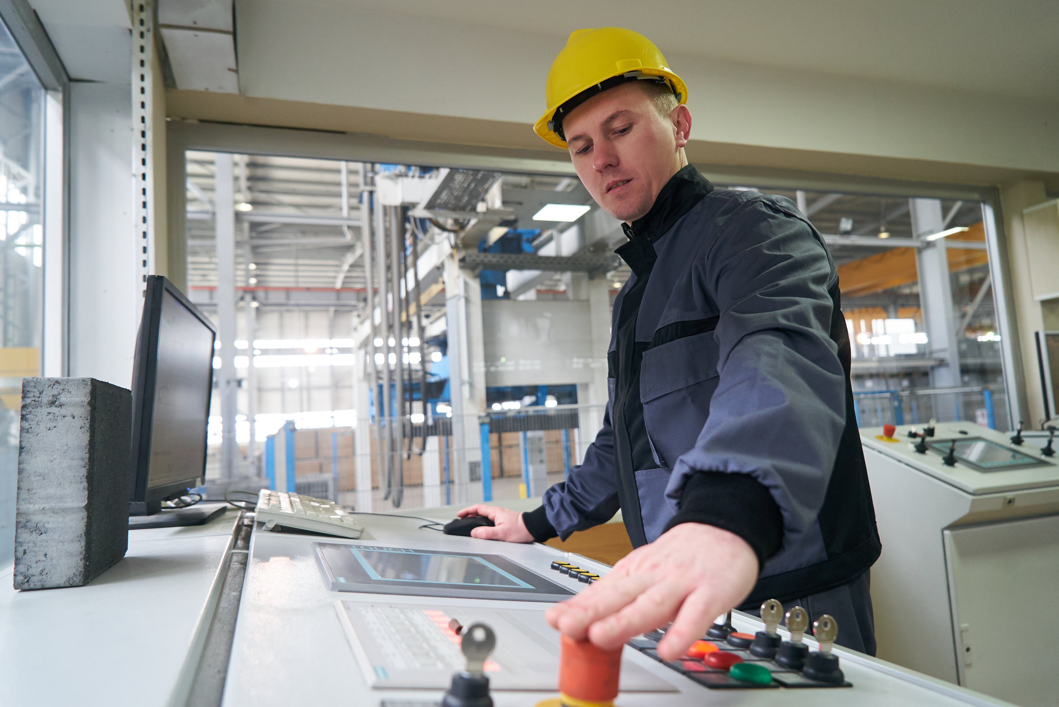 Engineer worker at control room. Portrait of a young technician worker in a factory. The operator monitors the work process from control room