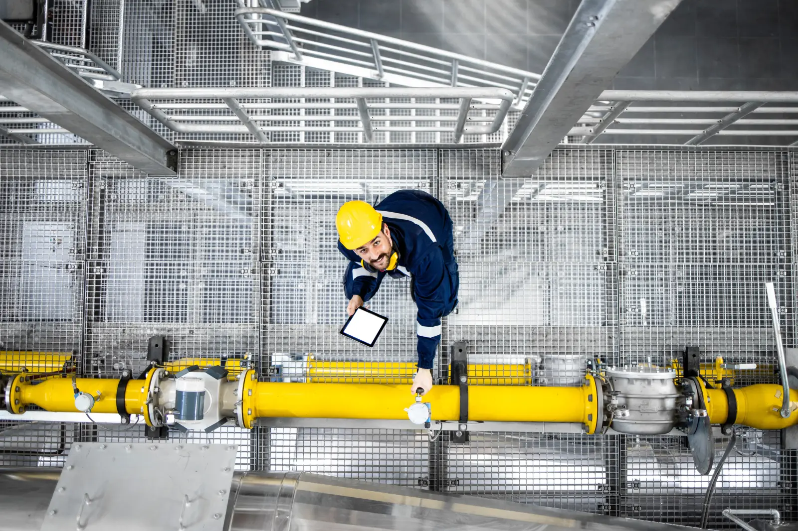Oil and gas maintenance process and top view of refinery worker checking gas pipes on oil production platform.