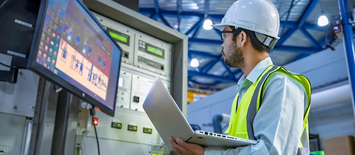 Professional engineer monitoring industrial automation system on digital screen in high-tech factory control room. Concept of smart manufacturing, technical data analysis, and modern engineering.