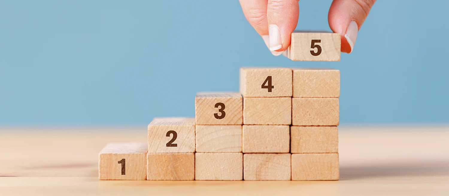 Woman's hand stacking numbered wooden blocks. Customer experience concept