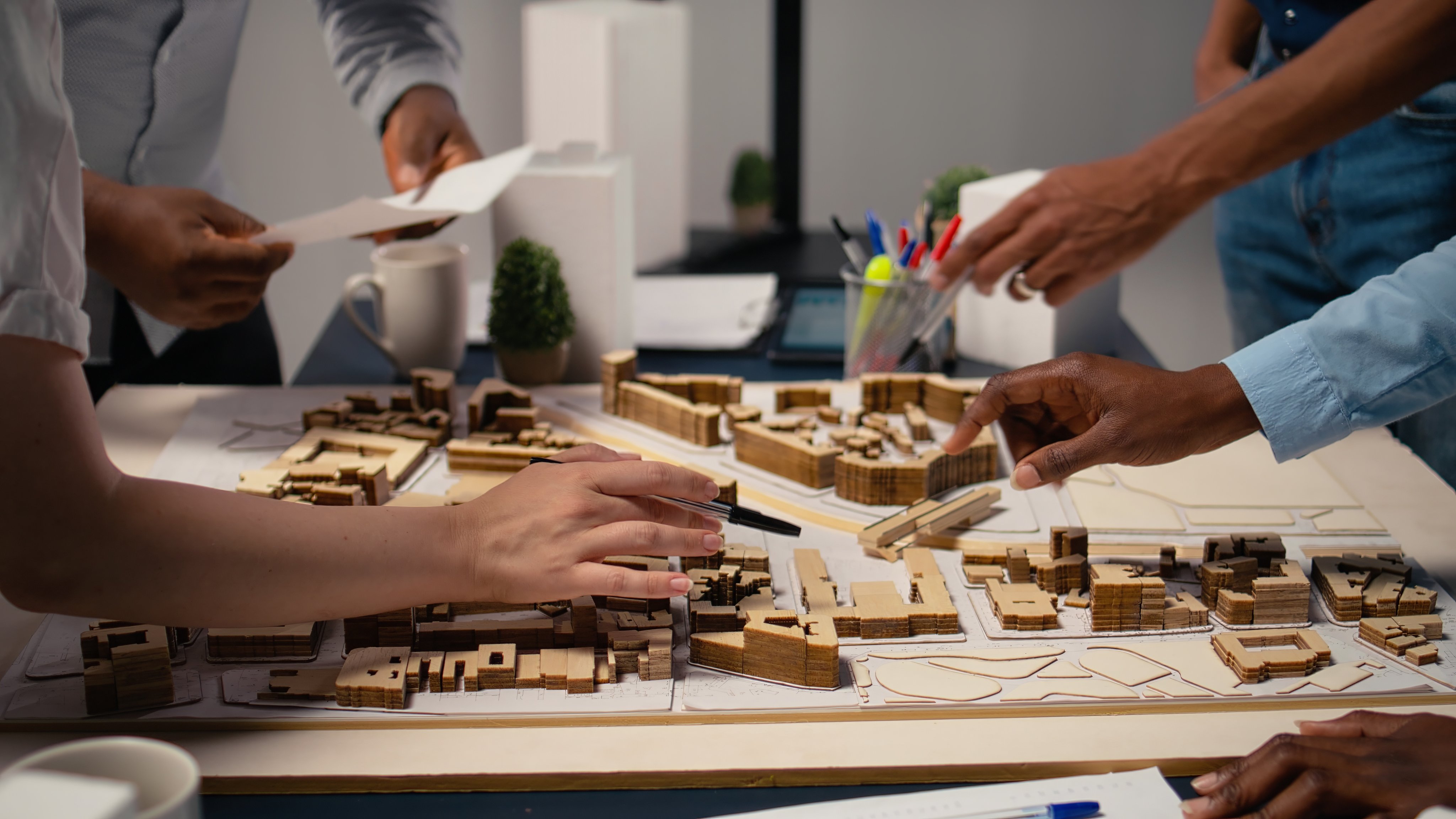 Close up of engineers team creating the property layout for site preparation, using 3D models for urban development and construction project. Infrastructure growth and city planning.
