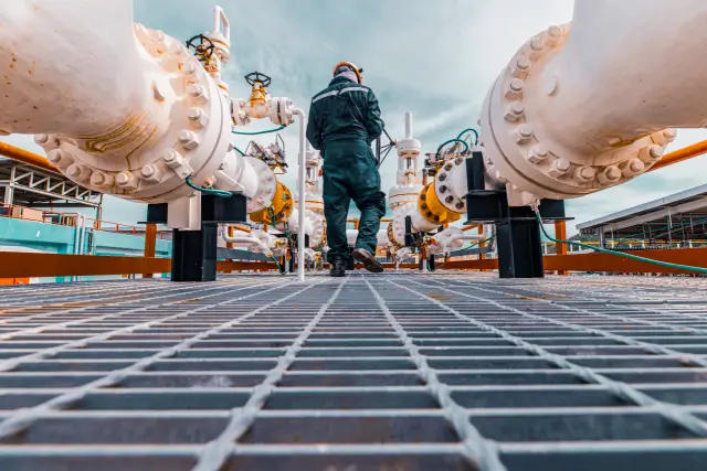 Male worker inspection at steel long pipes and pipe elbow in station oil factory during refinery valve of visual check record pipeline oil and gas