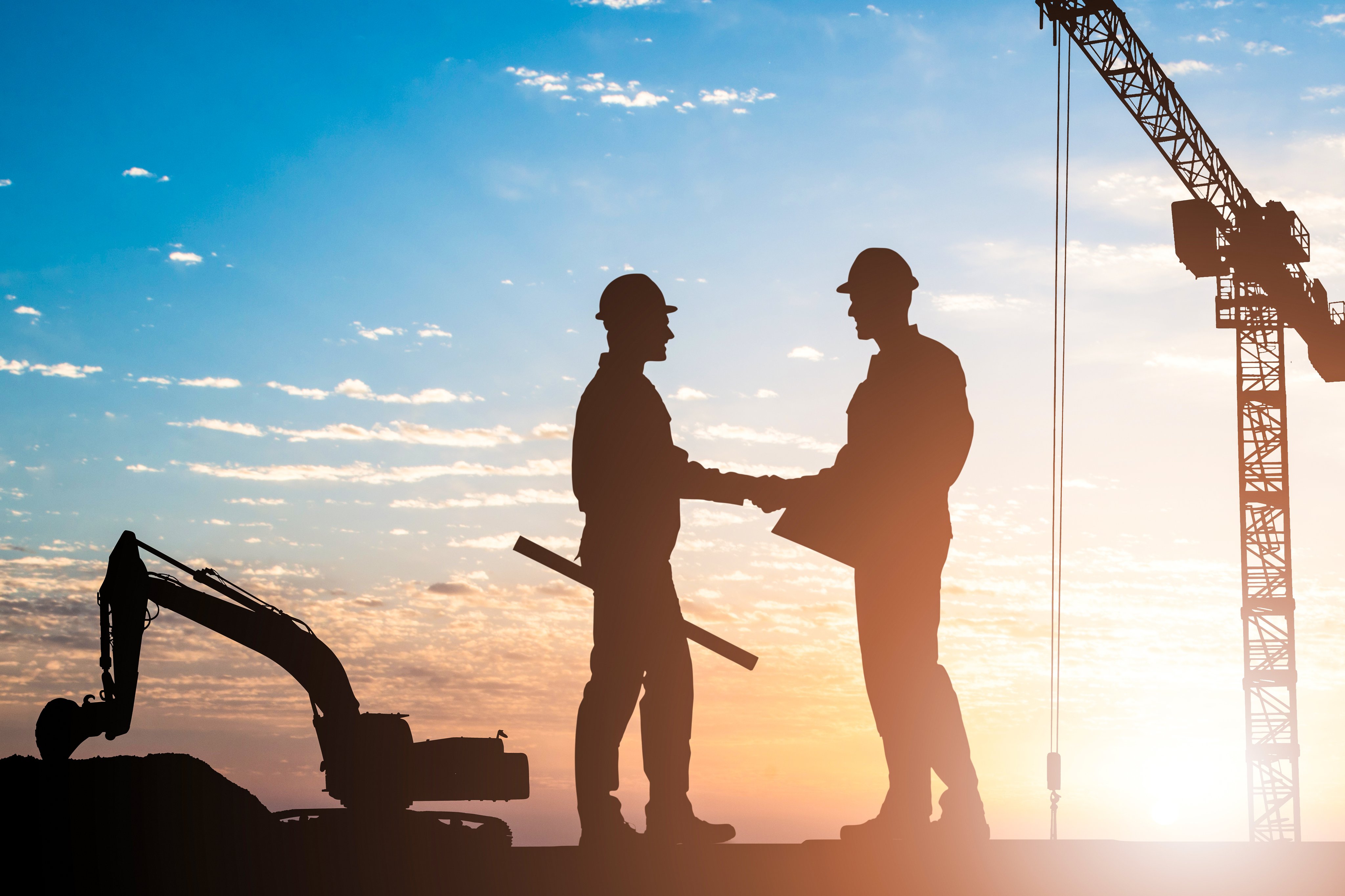 Side view of male architects shaking hands while standing outdoors