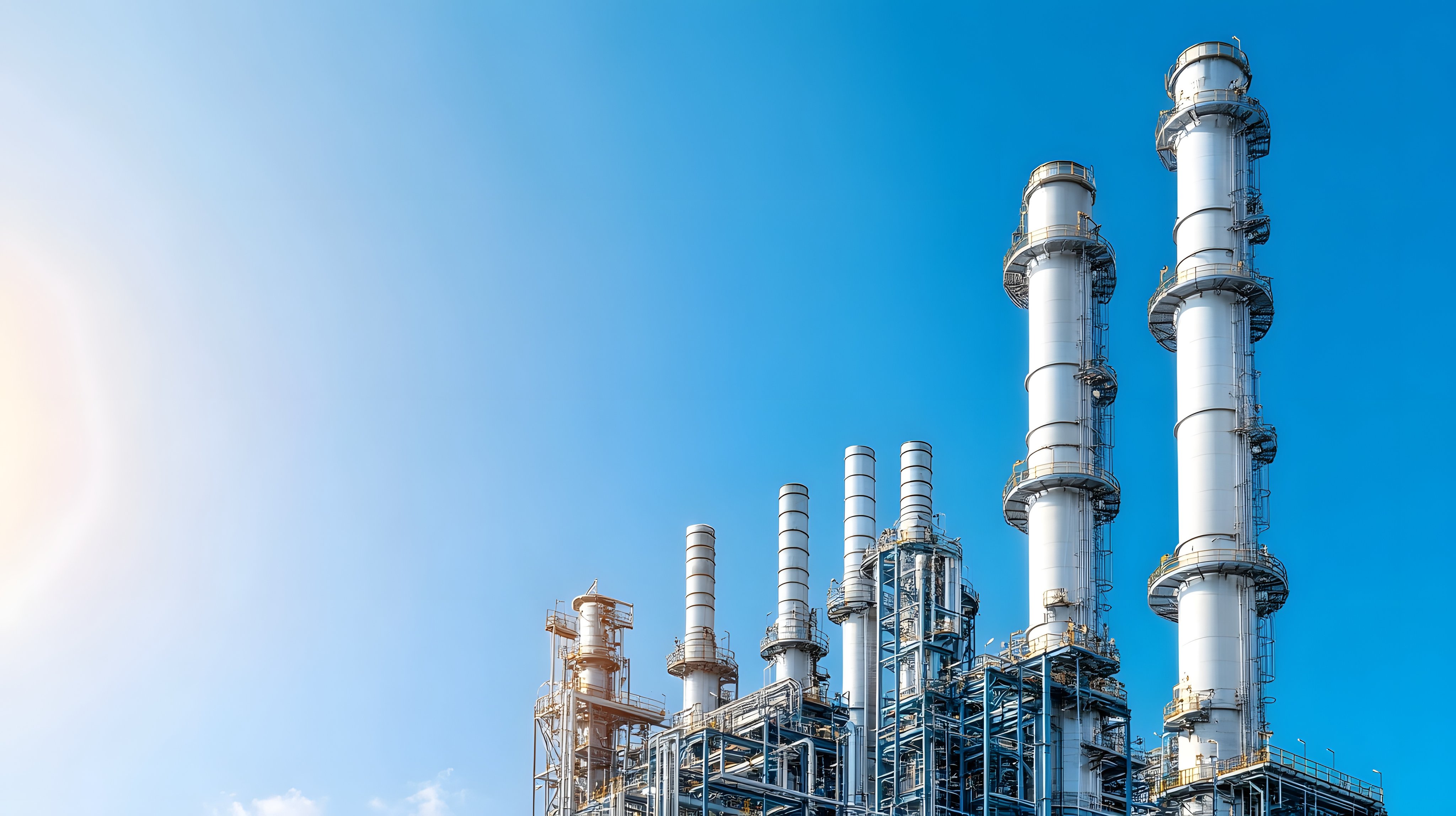 Sprawling high-tech oil refinery with towering processing structures under a clear, bright blue sky. Industrial energy and chemical production facility with advanced machinery and infrastructure.