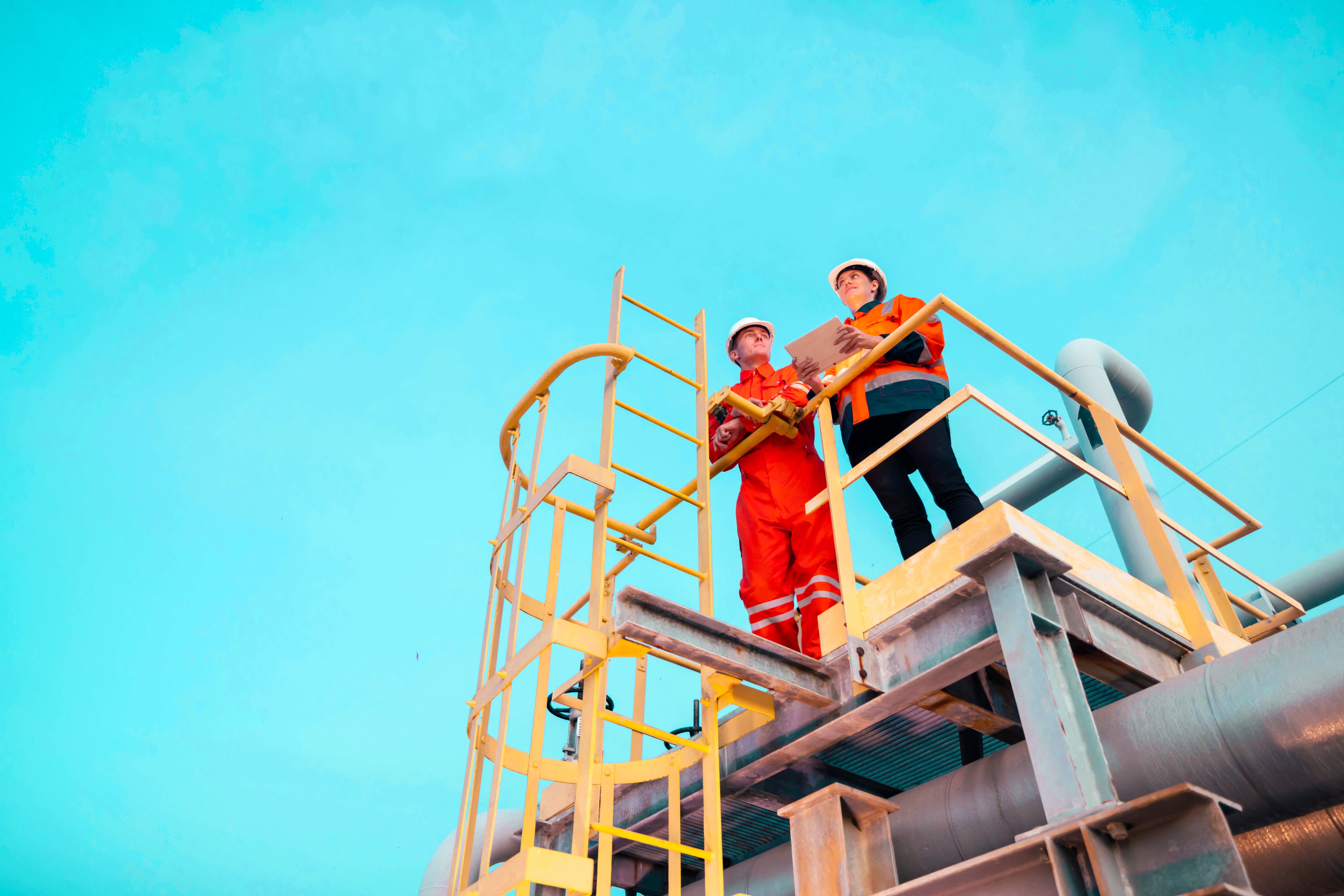Group of petroleum engineers having a discussion at oil refinery site