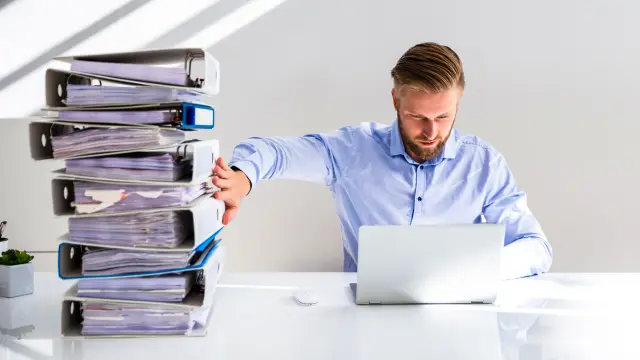 Businessperson Pushing Paper Documents Away And Working With Digital Documents On Computer Instead
