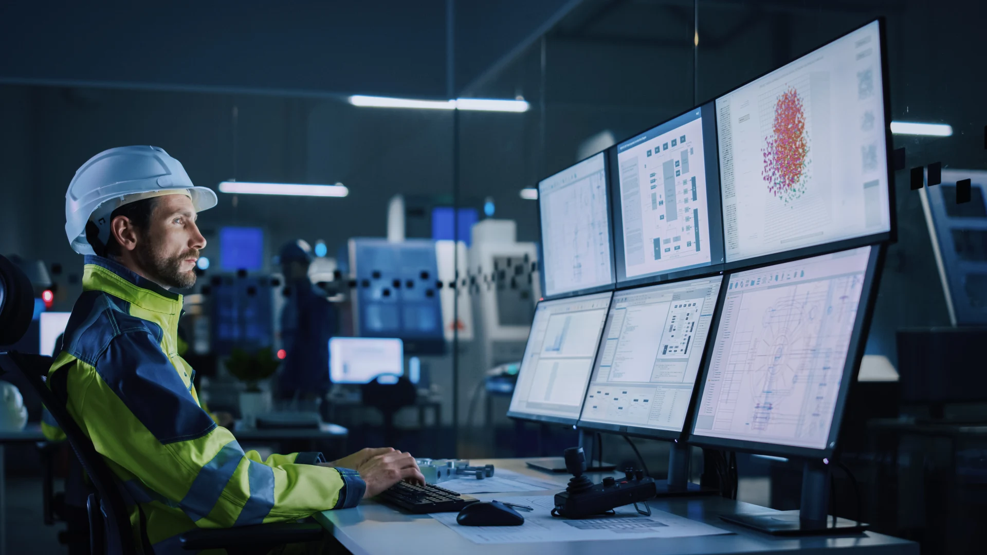 Industry 4.0 Modern Factory: Facility Operator Controls Workshop Production Line, Uses Computer with Screens Showing Complex UI of Machine Operation Processes, Controllers, Machinery Blueprints