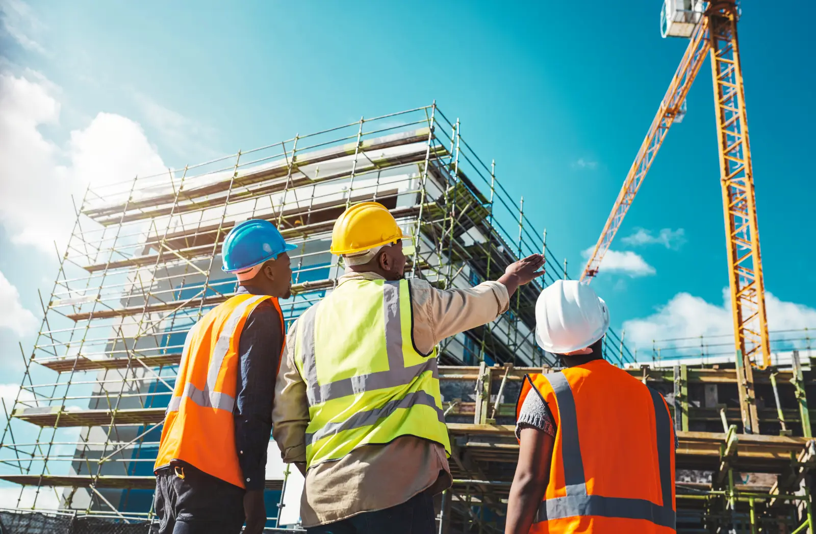 Engineering, construction site and team outdoor for building project, planning and architecture. Black woman and men contractor together for development and safety assessment discussion in city.