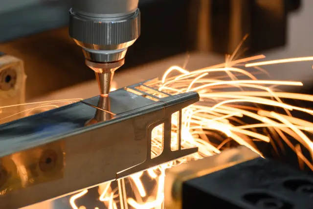 Close up scene the fiber laser cutting machine cut the square shape stainless steel tube with sparkling light. The high technology sheet metal manufacturing process by laser cutting machine. 