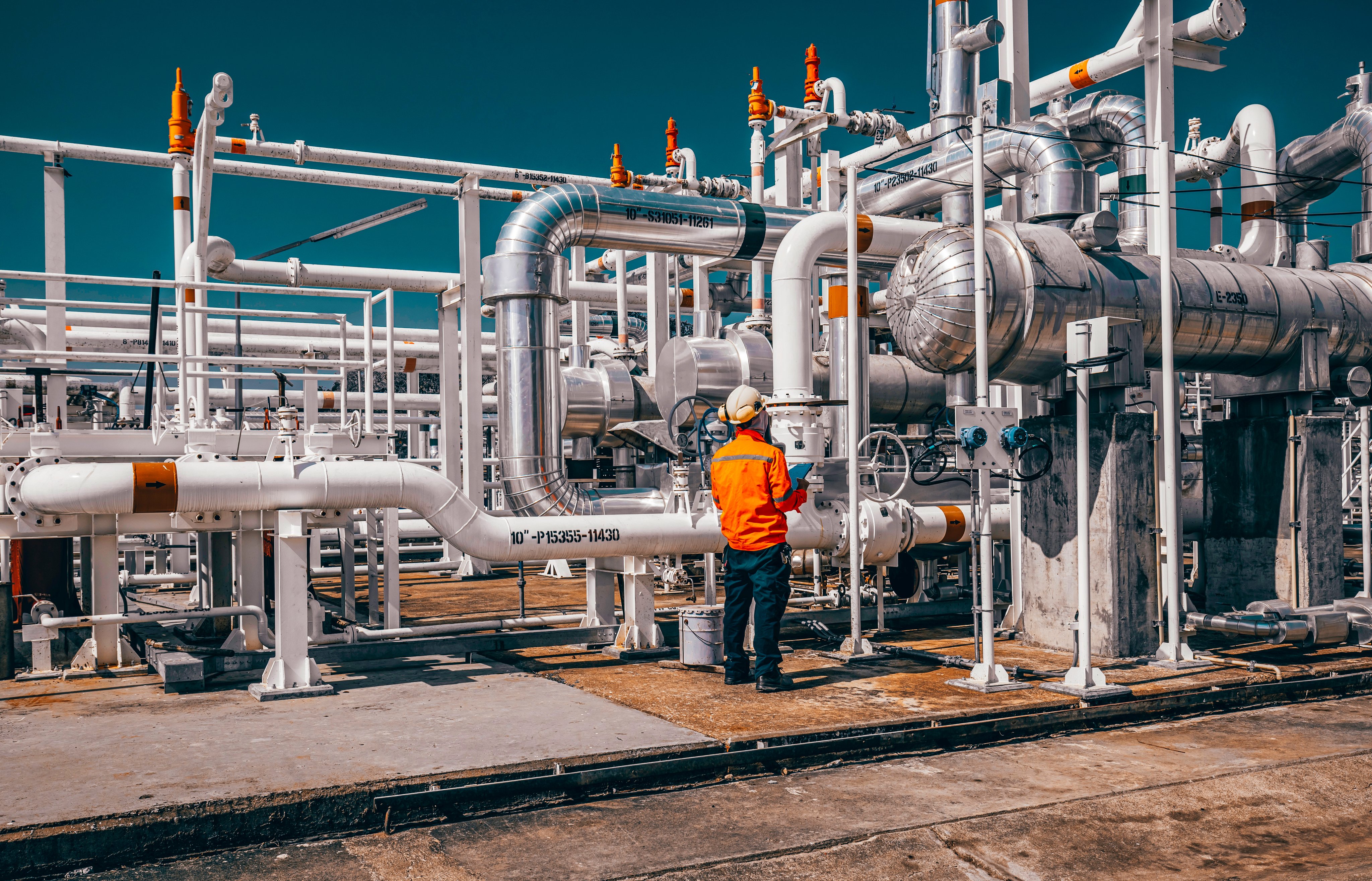 Male worker inspection exchanger afternoon of tank oil refinery pipeline plant steam vessel and column tank oil of Petrochemistry industry.