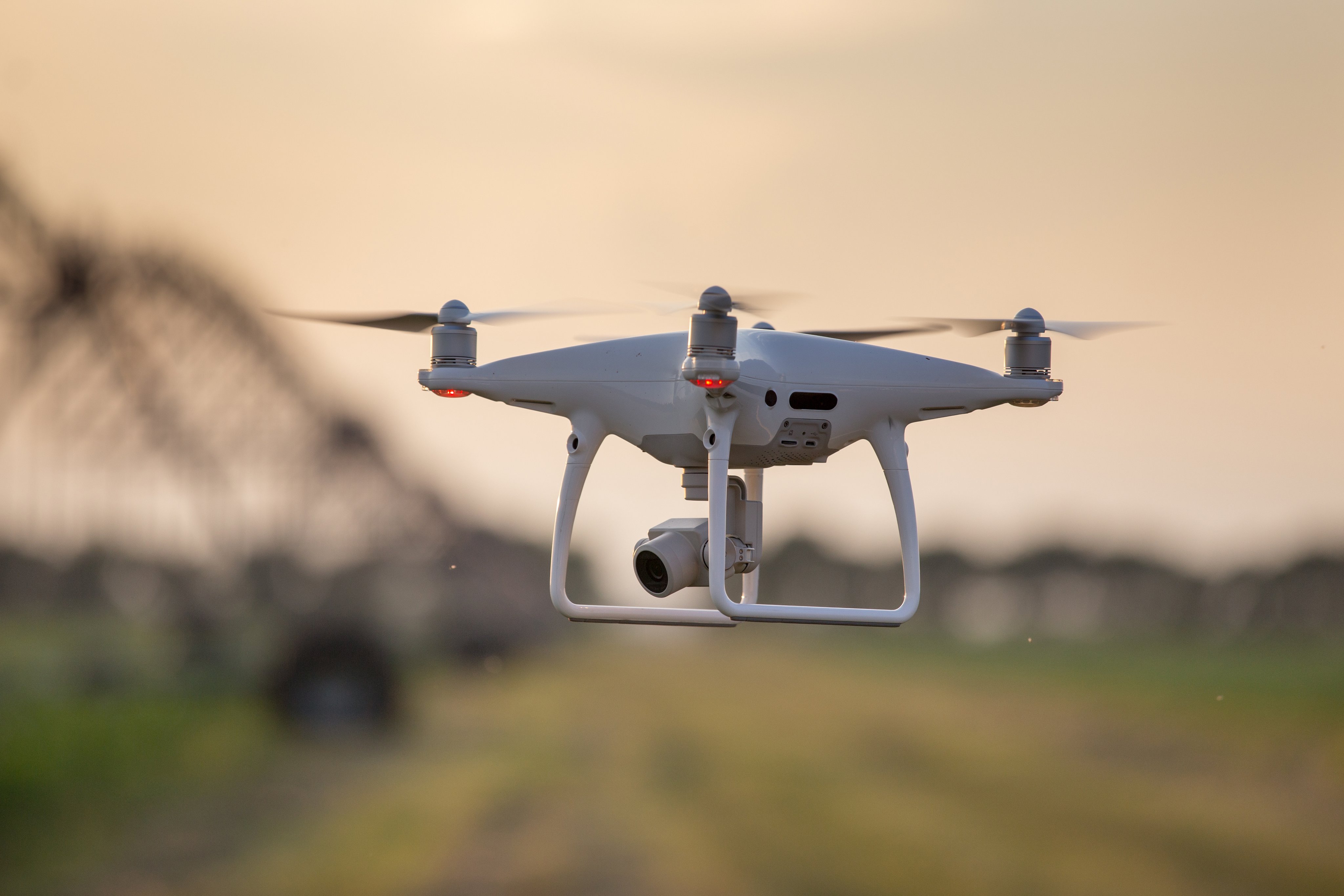 Close up of flying drone above farmland with irrigation system in background. Agricultural and technology innovations in production