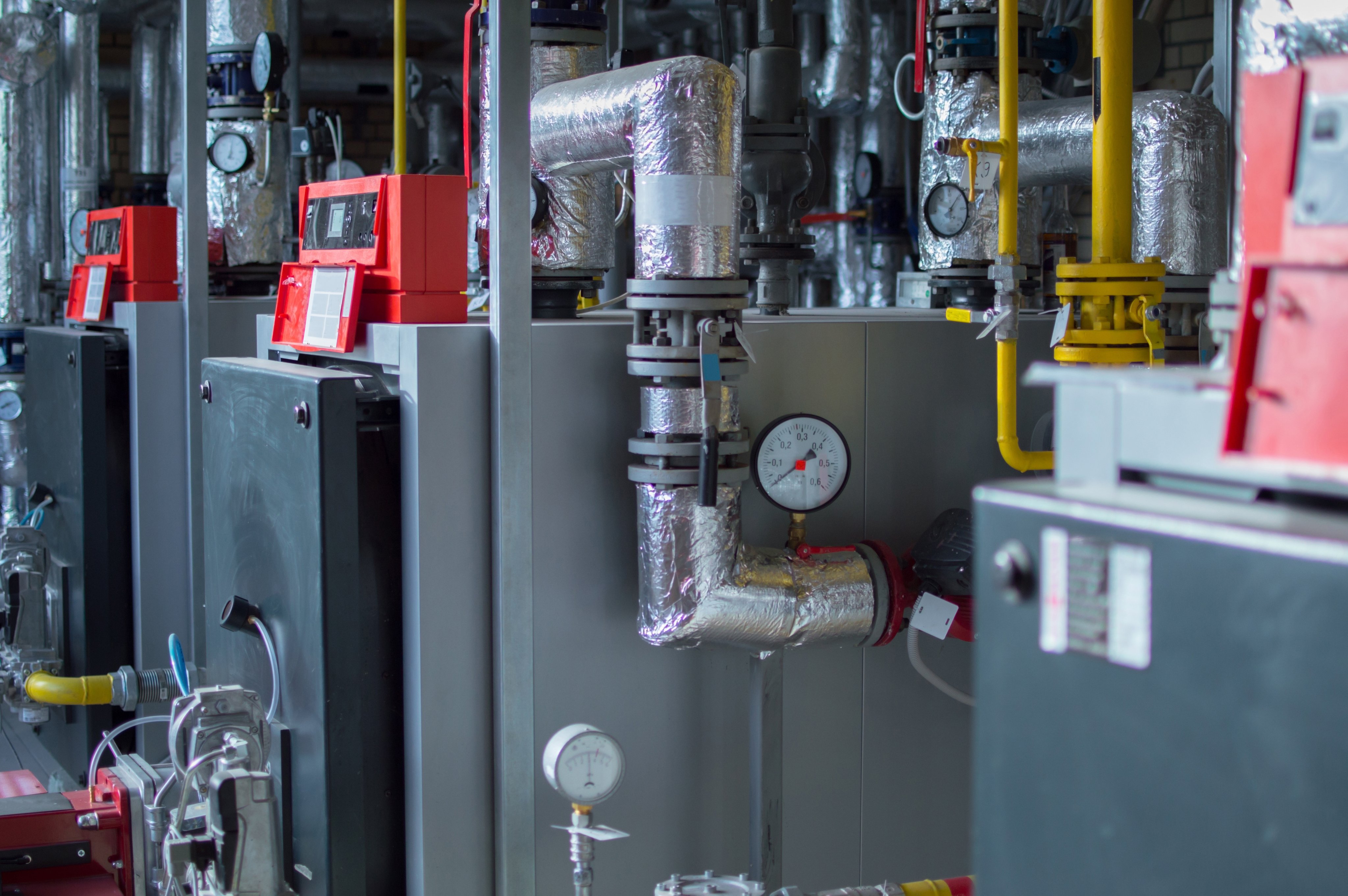 Modern industrial grey gas boilers with red natural gas burners in the gas boiler plant