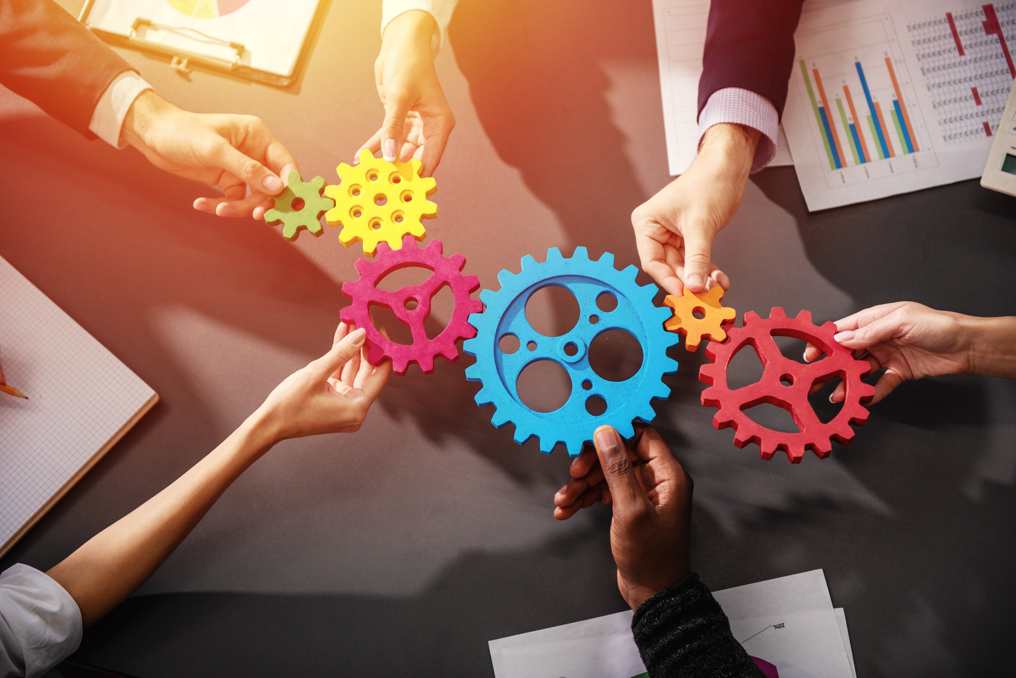 Teamwork of businesspeople work together and combine pieces of gears. Partnership and integration concept