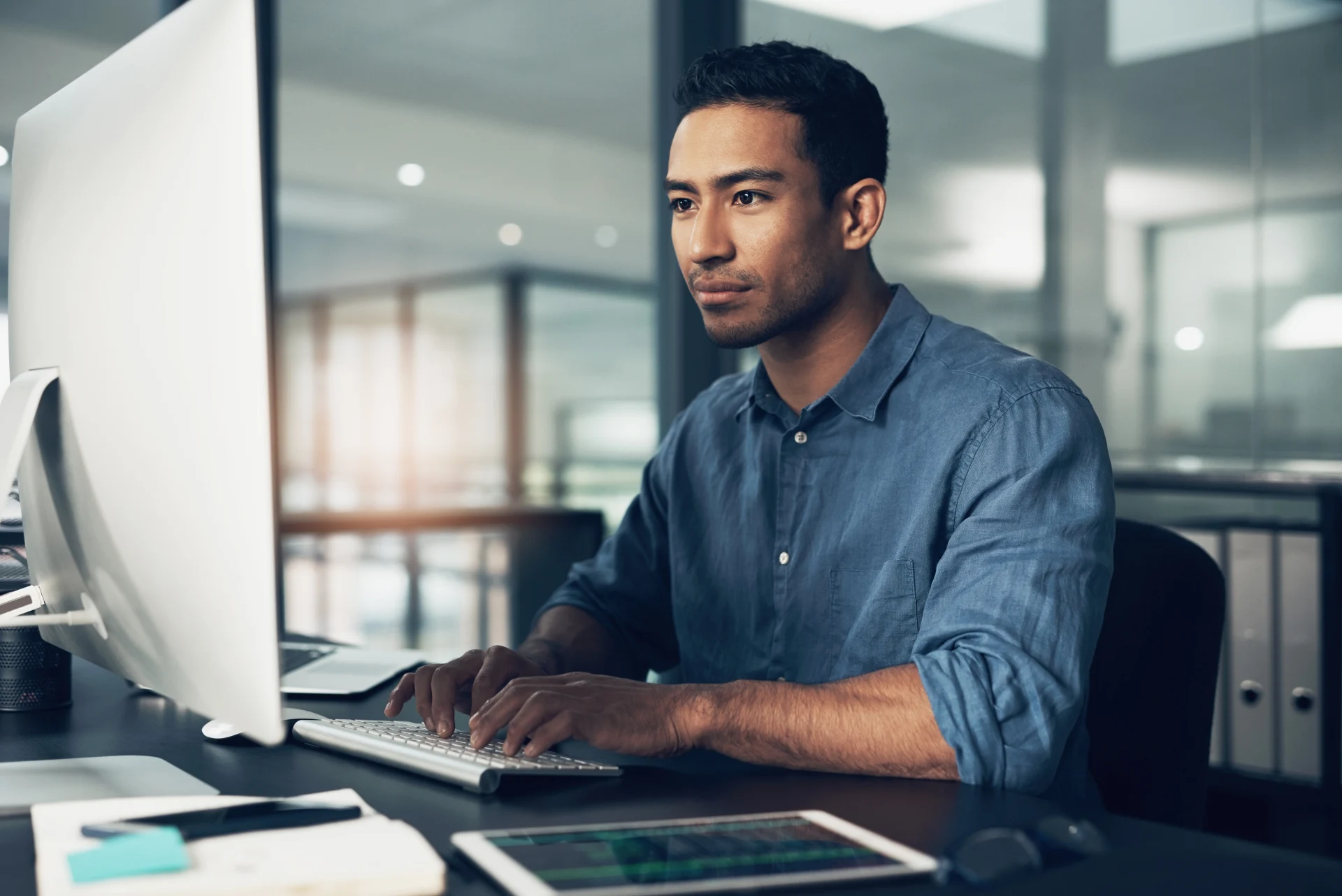 Typing, man and programmer on computer in office at night for deadline. IT, focus and male coder, engineer or person programming, coding and writing software, development and information technology