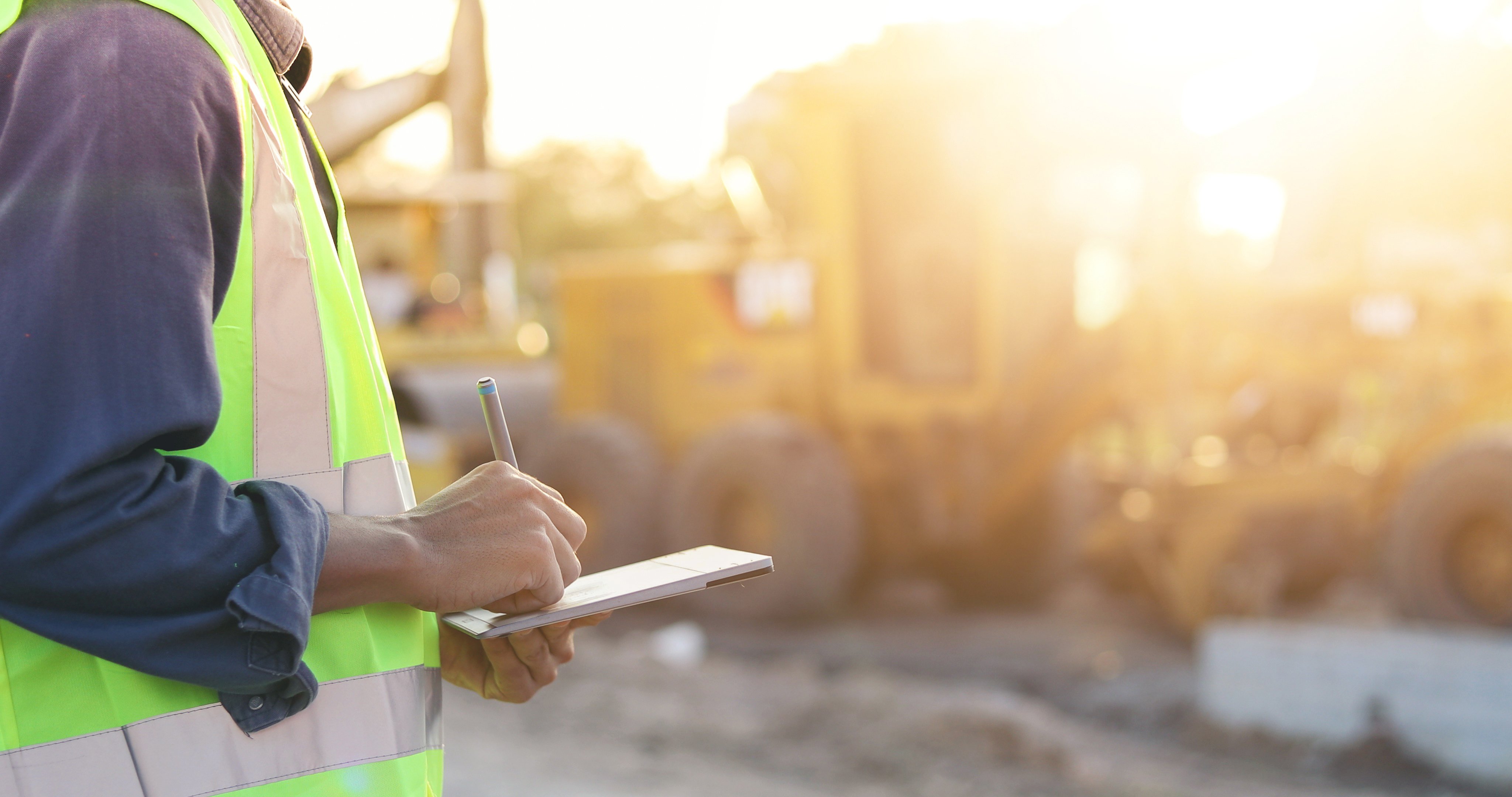 Asian engineer with hardhat using  tablet pc computer inspecting and working at construction site
