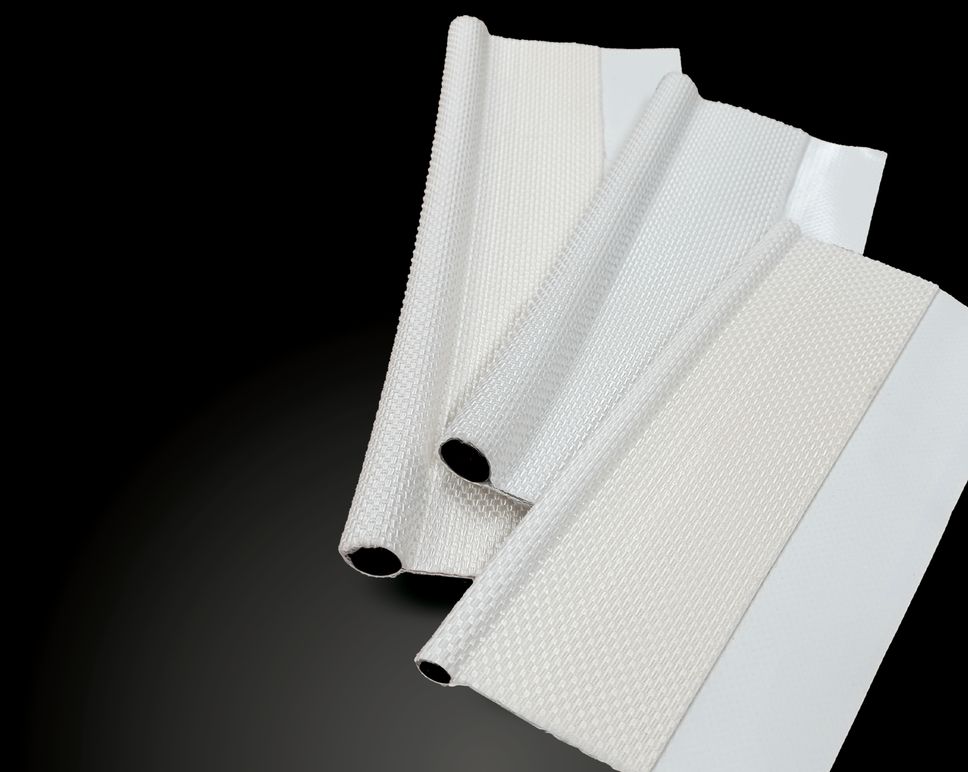 Three white keder strips, cord cores showing at the cut ends, on a black background