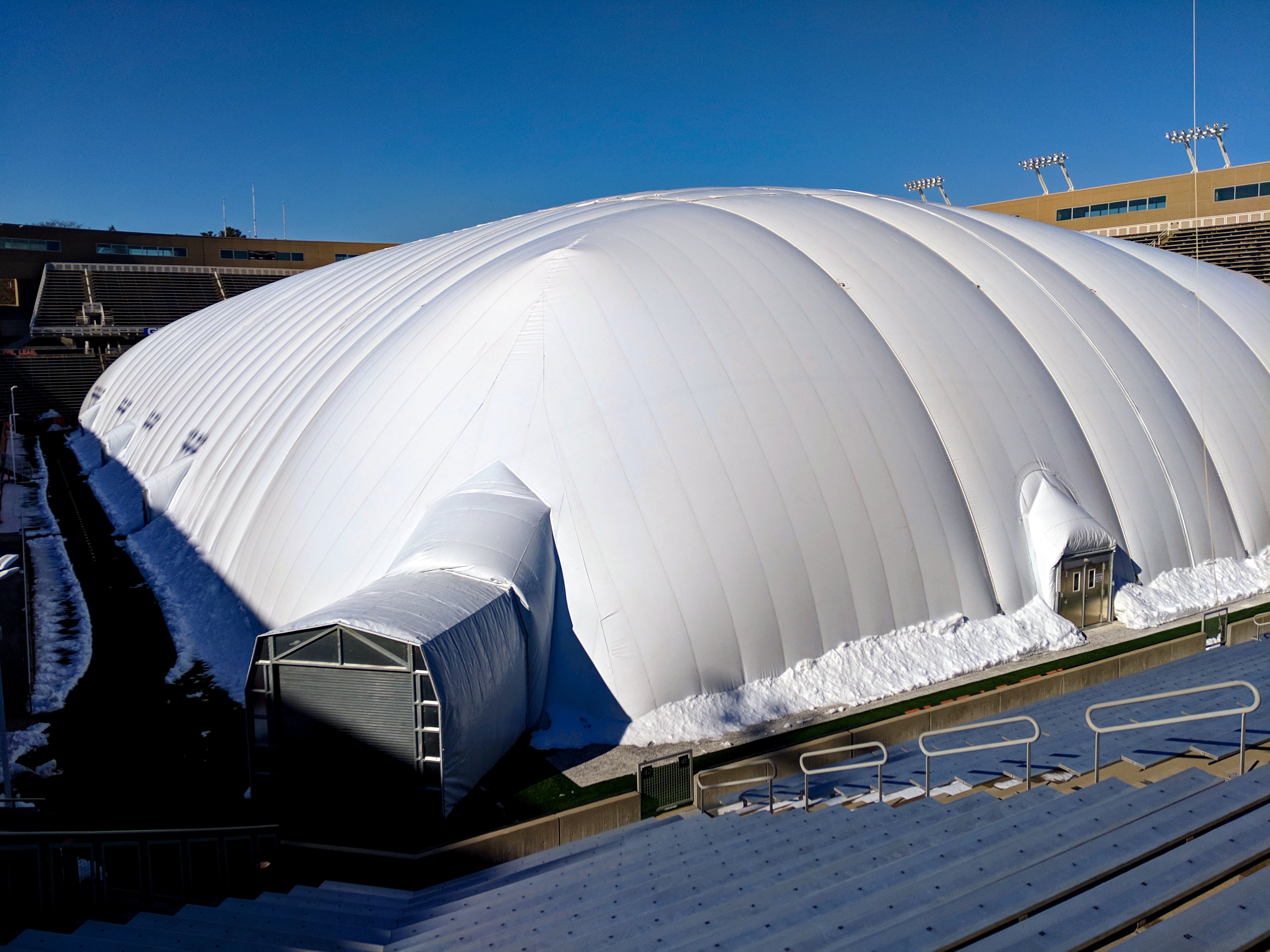 Air dome structure anchored inside a stadium field