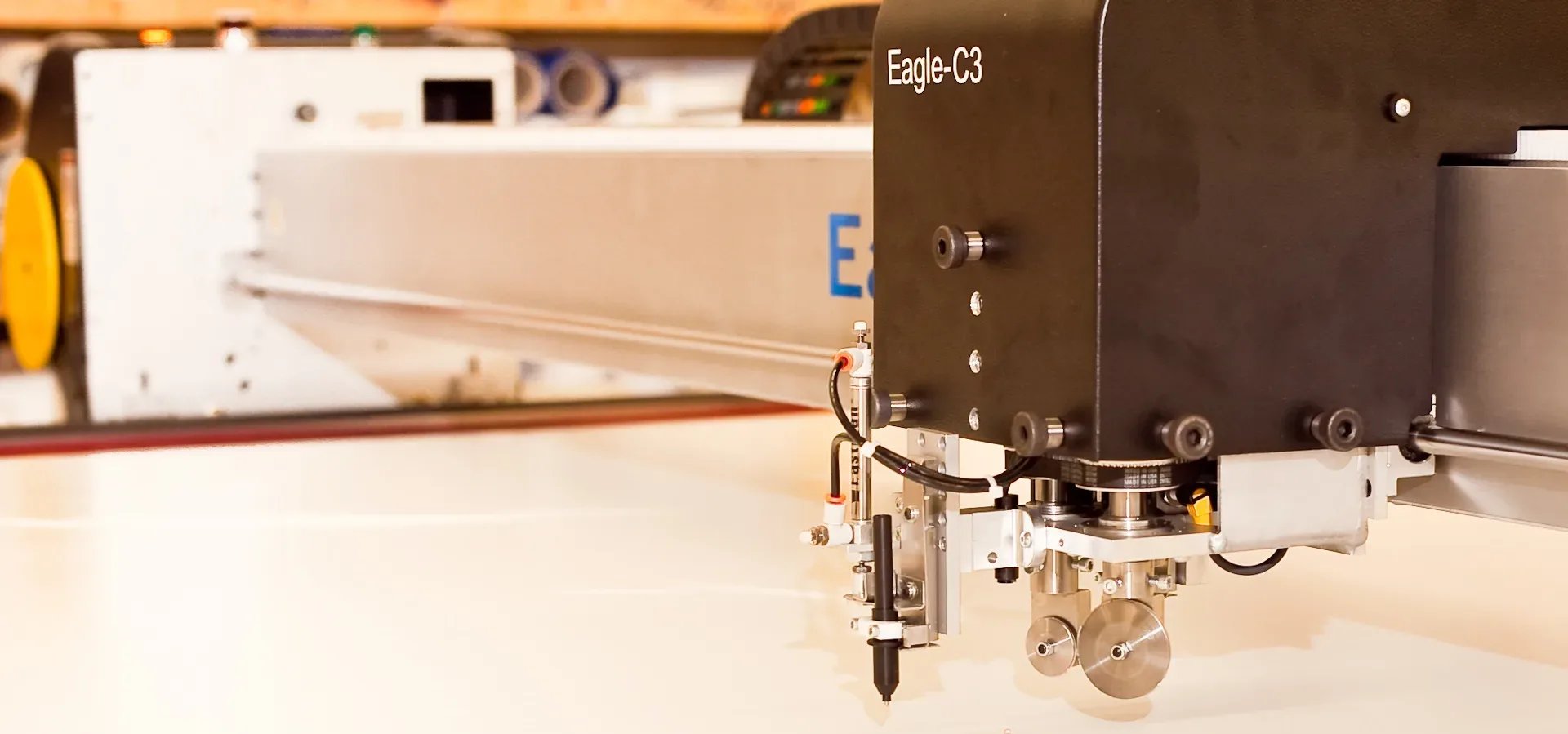 Automated cutting head over white fabric on a cutting table
