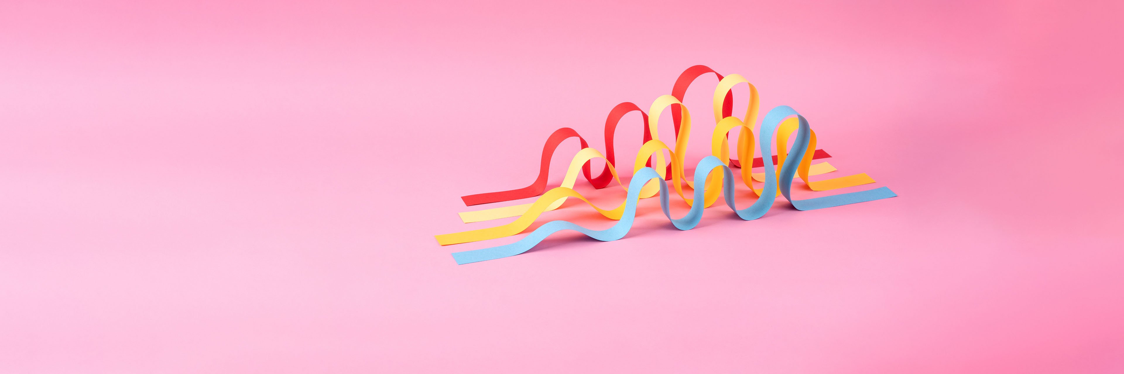 Colorful ribbons on a pink background