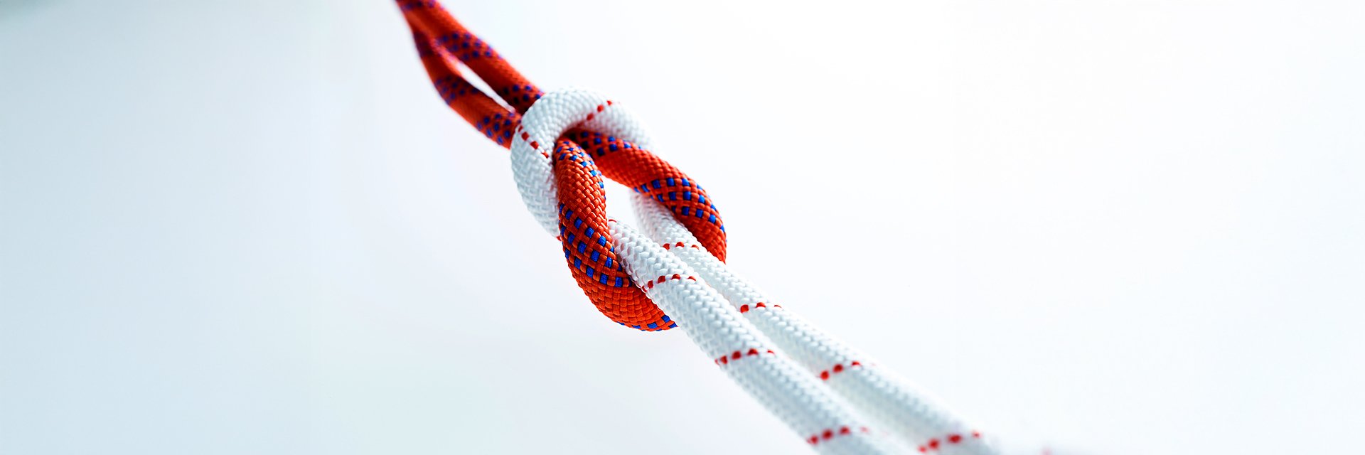 a red and white rope tied together on a white background