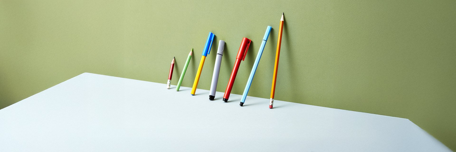 pens lined up against a green background
