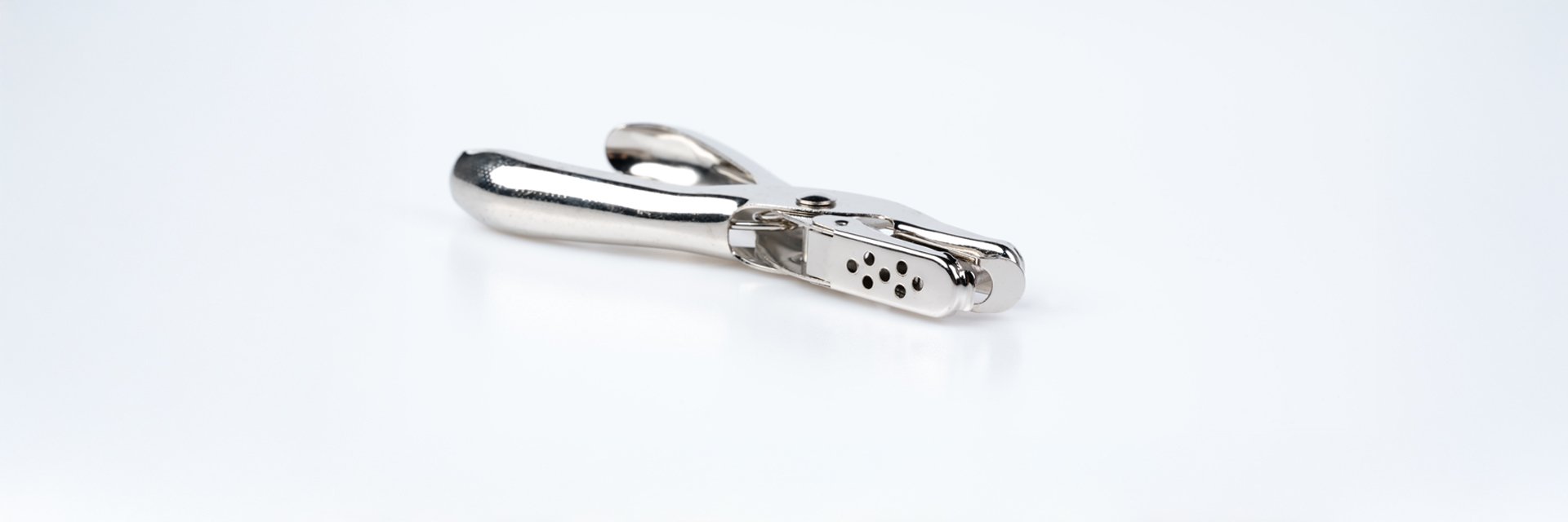 a metal hole puncher on a white background