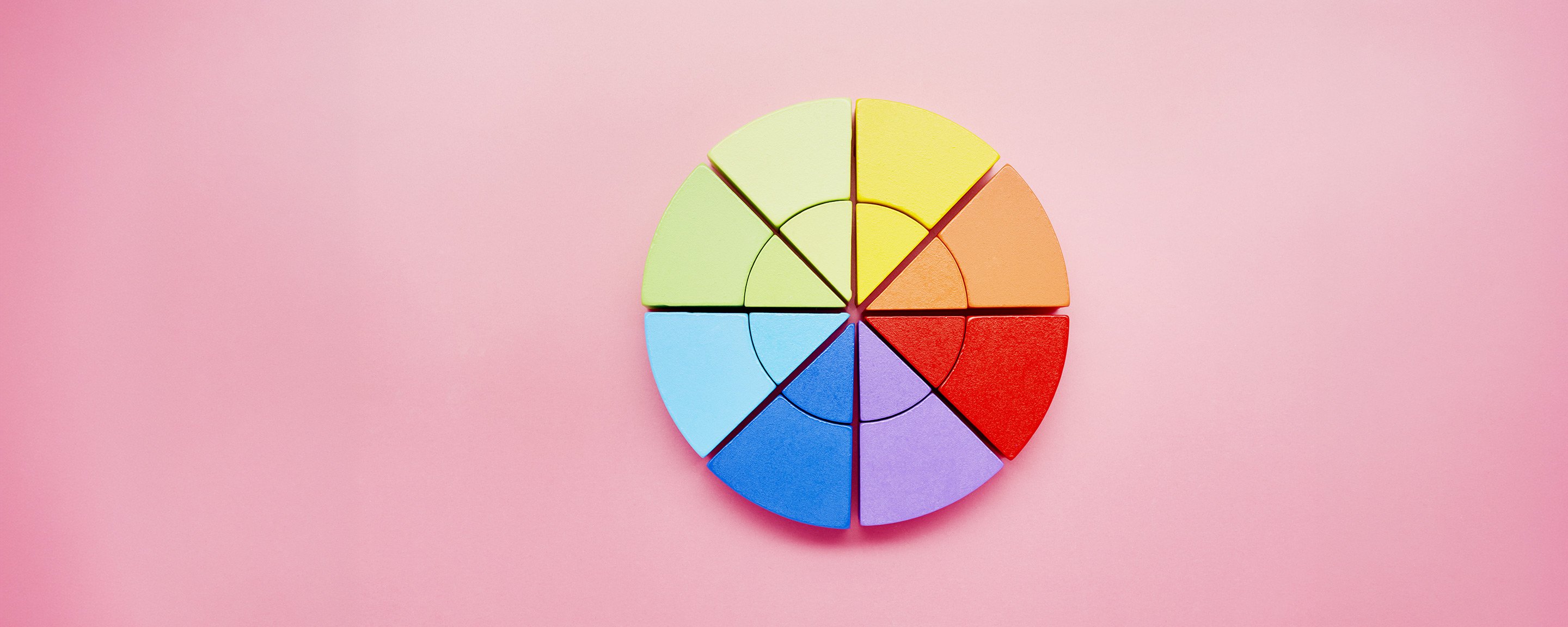 a rainbow pie chart on a pink background