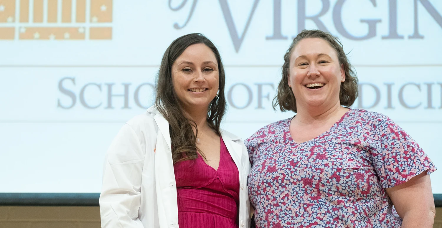 Student and mentor standing together on stage at the 2023 School of Medicine White Coat Ceremony.