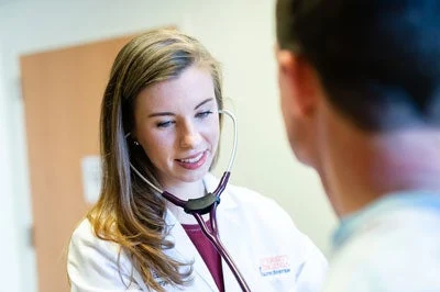 UVA Surgery Resident checking a patient's heartbeat.